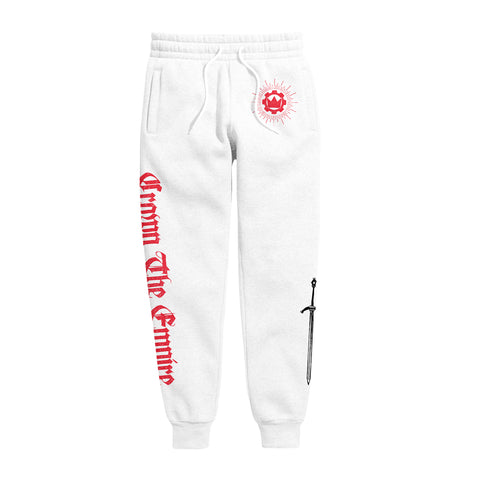 image of white sweatpants on a white background. left leg has red print that says crown the empire. small red print of the crown emblem on the right hip, and black print of a sword on the bottom right leg